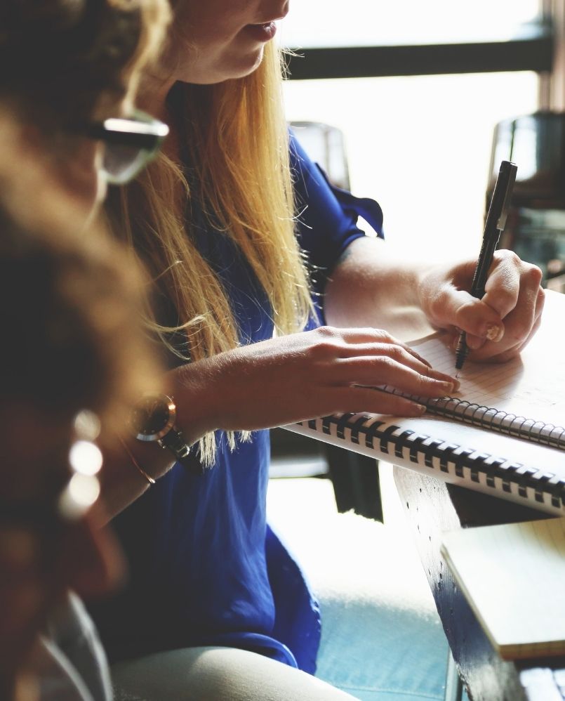 a woman working on a project and writing down ideas